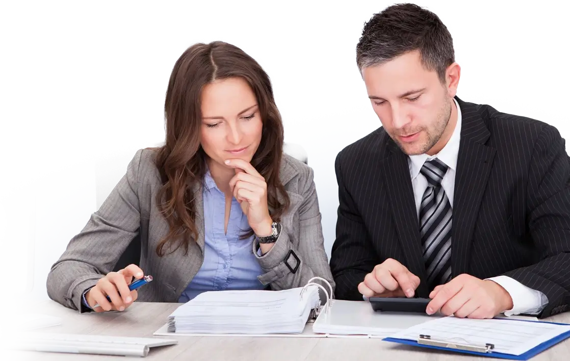 Two people sitting at a table with papers and calculators.